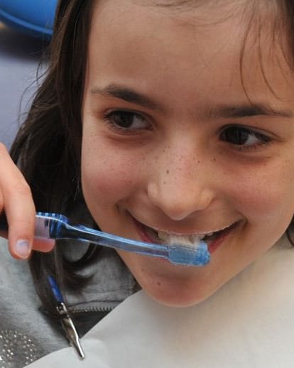 Una nena aprenent a raspallar-se les dents